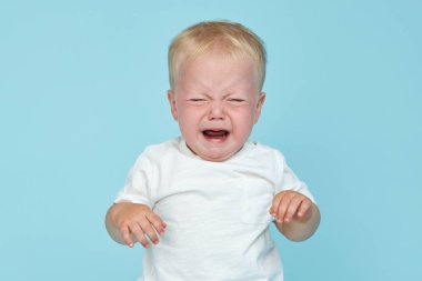 Küçük bebek mavi arka planda ağlıyor