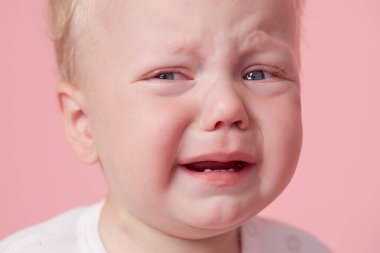 Pembe arka planda izole edilmiş ağlayan bebek.