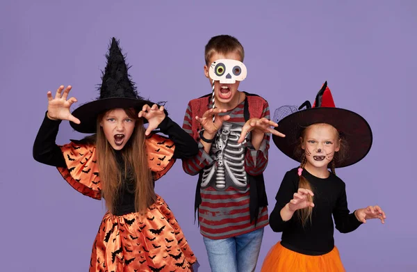 Niños Divertidos Trajes Carnaval Honor Halloween Sobre Fondo Púrpura —  Fotos de Stock