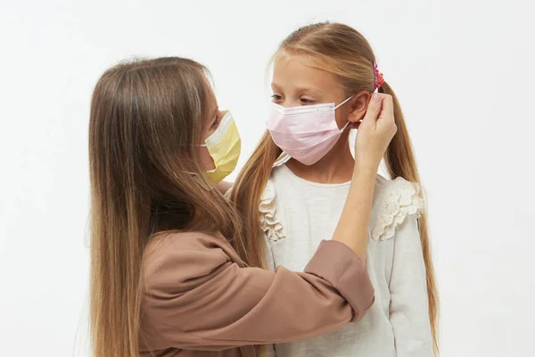 照顾所爱的人在Covid 19大流行病期间 年轻的母亲抱着戴着防护口罩的小女儿 工作室白色背景 — 图库照片