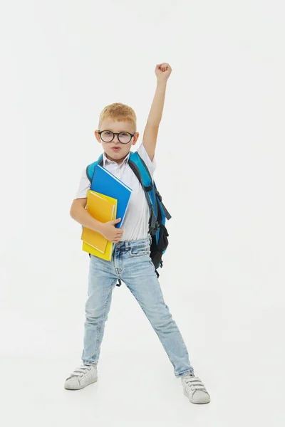 课间休息穿着校服的快乐淘气的学童 背着背包在白色背景上跳跃 假期开始了回学校去 — 图库照片