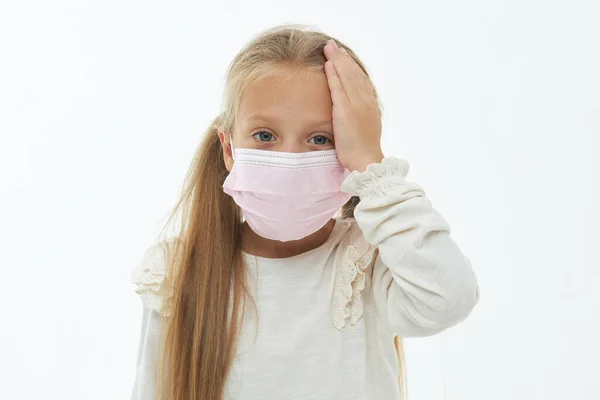 戴着防护面罩的可爱的生病的小女孩 手放在脖子上 在大流行病期间防止流感和感冒 白色孤立的背景 — 图库照片