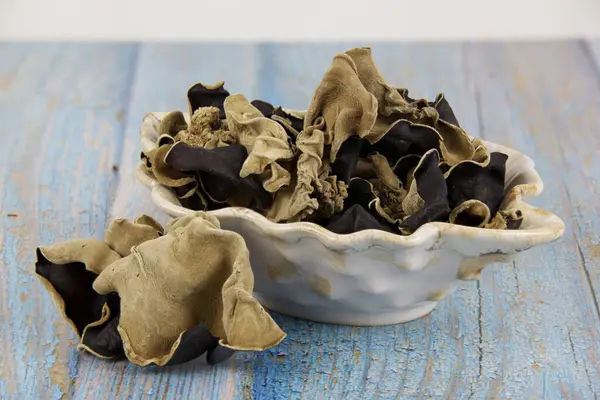 Yahudi kulağı ya da kulak mantarı olarak bilinen kurutulmuş mantarlar seramik tabakta, eski ahşap masa üzerinde, Asya mutfağında popülerdir.