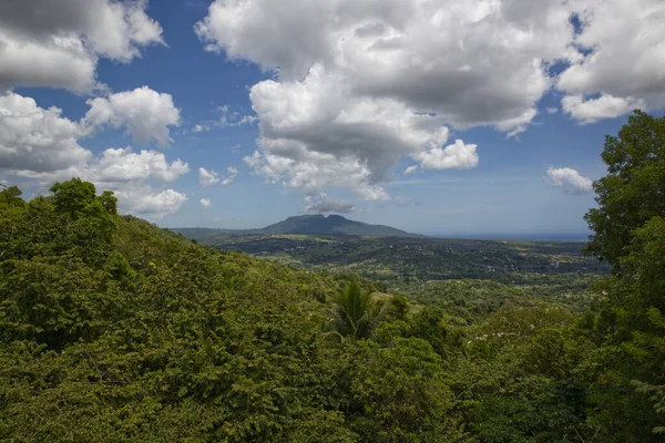 Dağların üzerinde bulutlu mavi gökyüzü, Karayip adasında yeşil yaz ormanı