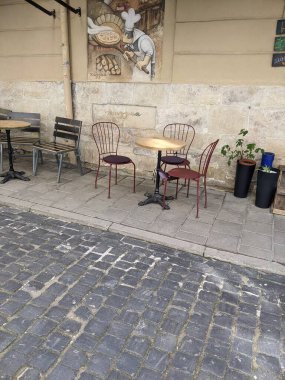 Sandalyeleri ve masaları olan sokak kafesi.