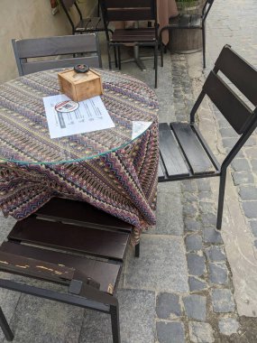 Sandalyeleri ve masaları olan eski ahşap masa.