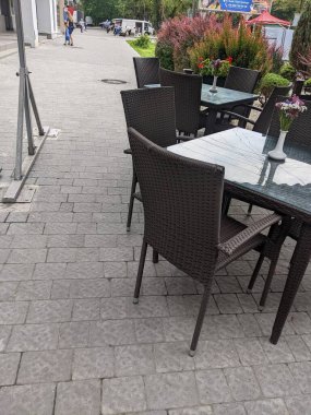 empty white table with chairs and tables on the street in the city of lviv