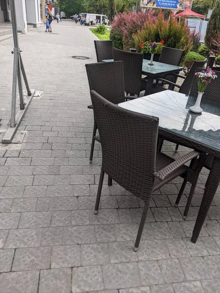 empty white table with chairs and tables on the street in the city of lviv