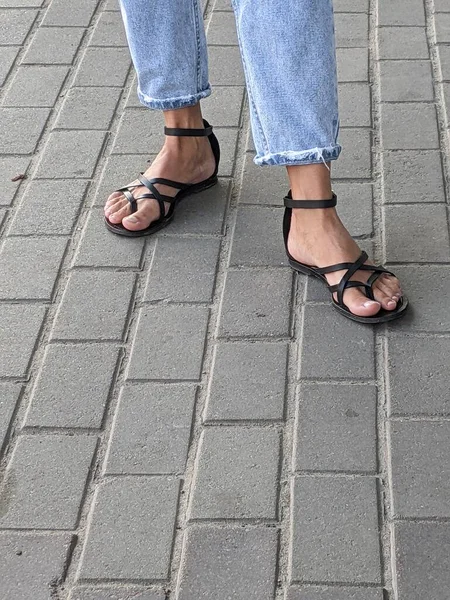 feet of a woman with a white shoes on the street