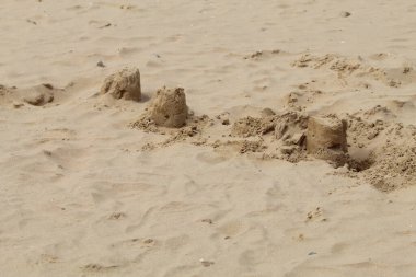 Liverpool, Merseyside 'daki Formby Sahili' nde oynayan çocuklar tarafından yapılmış kumdan kaleler ve hendekler..