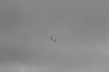 Liverpool, Merseyside 'daki Formby Sahili' nde gökyüzünde uçan bir uçak. Bu fotoğraf bir yaz öğleden sonra çekildi, görüntüdeki bulutlu ve gri gökyüzüne rağmen.