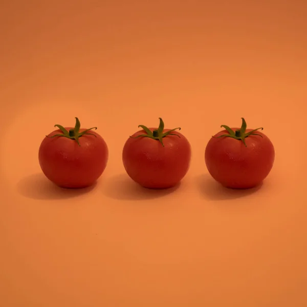 Rote Tomaten Mit Grünen Blättern Auf Orangenem Hintergrund — Stockfoto