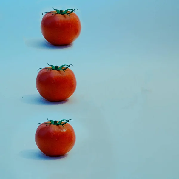 Trois Tomates Fraîches Isolées Sur Fond Bleu Concept Pose Plate — Photo