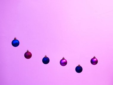 Pembe arka planda Noel ve Yeni Yıl süsleri.