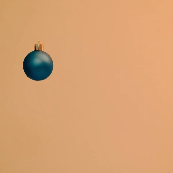 Simple Christmas  decoration, sweet blue ball on yellow background.