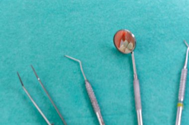 Diş aletleri diş muayenehanesinde kullanıma hazır, kaşif aynası, curettes, yeşil, mavi, nane, pembe ve siyah arka planda