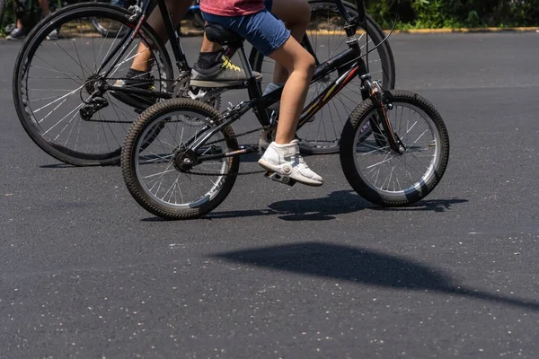 young man with customized bicycle shows off his style riding down the street on a sunny day. Sik litmus glasses, baseball t-shirt, paddle shoes and other accessories on the bike.