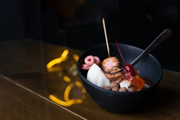 ice dessert with sweet toppings, Strawberry Bingsoo or Bingsu with soft focus, using as a background or wallpaper the dessert shows burnt marshmallow, colored cereal, chocolate cereal, panda-shaped