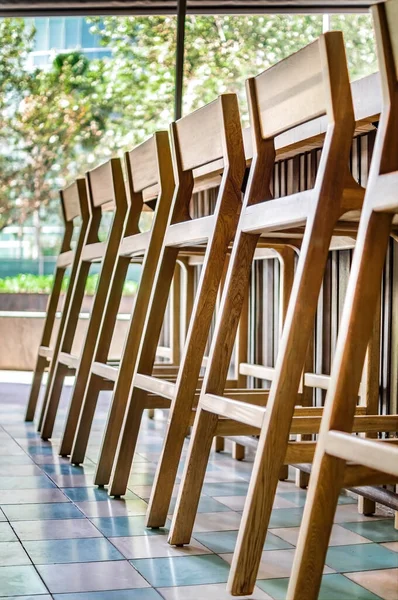 bar stools or benches, with thick pasta floor, at the back vegetation, bar and counter bar. You can see out of focus bottles of alcohol, the benches are made of solid wood, oak, oak. All design