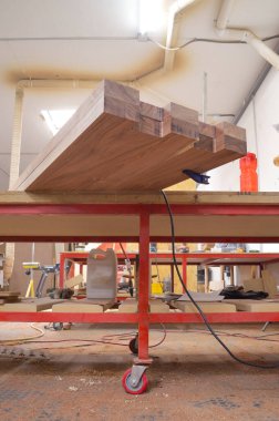 A man cuts wood on a circular saw in a joinery, A man cuts wood on a circular saw in a joinery, band saw, holding a plank, two-inch wood plank being cut, in a woodworking shop