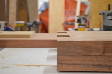A man cuts wood on a circular saw in a joinery, A man cuts wood on a circular saw in a joinery, band saw, holding a plank, two-inch wood plank being cut, in a woodworking shop