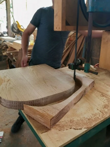 band saw wood cutting, back of an armchair, furniture design, the wood is natural oak, solid wood or hardwood. The cutting is hand made by a carpenter.