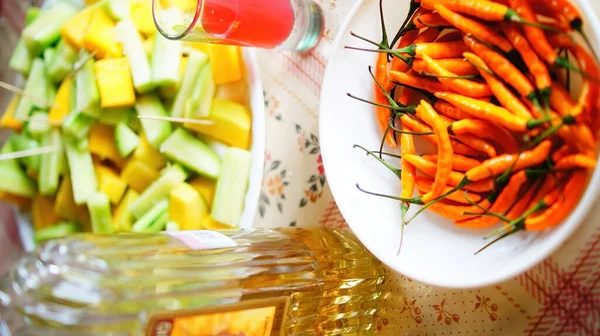 family reunion, sharing food or snack, fruit, cucumber, mango, prepared with salt and lemon, alcoholic beverages, such as flavored tequila, chile orange as a snack.