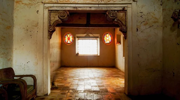 interior of a hacienda, or mexican house in latin america, entrance of light to contrast with the space, light and shadow, window, person observing. antique wood, antiques