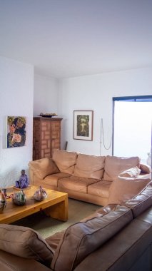 large natural leather armchair, solid wood table in the center, living room, mexican decoration, mexico and latin america, rug.