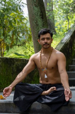 Om 'un Sanskritçe yazılmış sesi Hindu ve Vedic geleneklerinin kutsal sesi, orijinal mantra. Yoga ve meditasyon tekniklerinde kullanılır. Kumda Frangipani çiçekleri