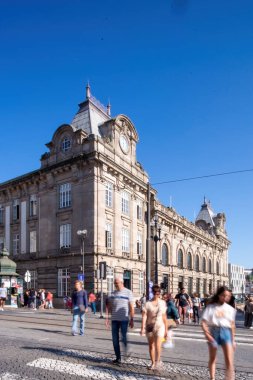 three people walking castle or church, dirt floor and trees in foreground. The stone church with clay tile roof, clear sky. sense of exploration, discovering architecture.