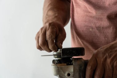 Latin adam alet çantasında aletler arıyor, İspanyol, Meksikalı, elinde tornavidayla.