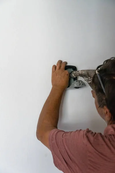 man installing password protected box that stores door access keys, mexico latin america