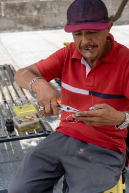 Sokakta el yapımı metal biblolarla bisiklet heykelcikleri yapan bir zanaatkar. Meksika Guadalajara.