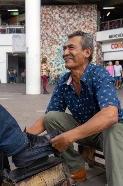 Yıkanma kabında sabunlu suyla yıkanmış ayakkabılar. Kirli ayakkabıları yıkamak, sokakta ayakkabıları temizlemek, Latin yaşlı adam, Meksika Guadalajara