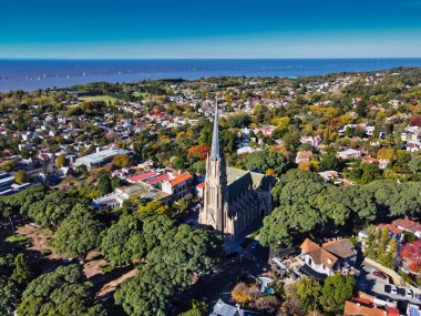 Katedral de San Isidro Labrador en Buenos Aires y de fondo una regata en el rio de la plata