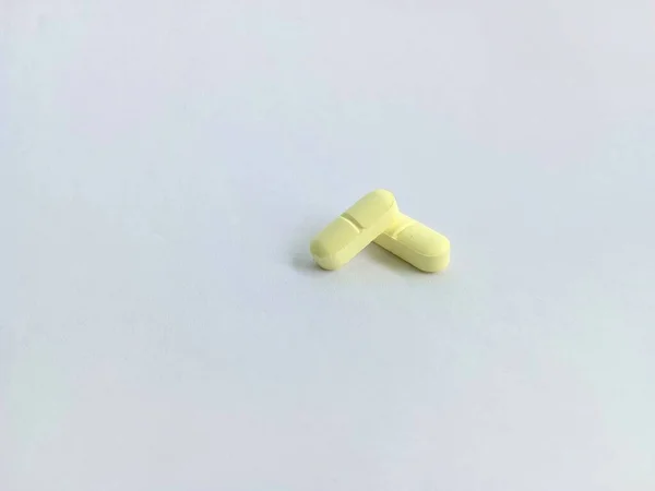 Дві Маленькі Жовті Таблетки Або Таблетки Ізольовані Білому Тлі Або — стокове фото