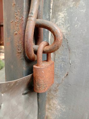 Paslı asma kilit ve demir kapının yakın çekimi. .