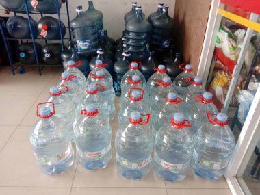 Jakarta, Endonezya-6 Temmuz 2022: Mini market dükkanının önünde düzgünce düzenlenmiş galon şişe su