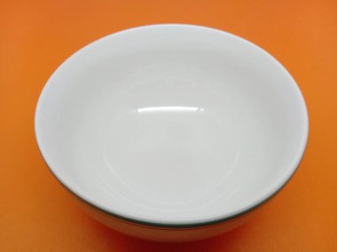 Portakalda izole edilmiş boş bir seramik kase. Yaklaş.