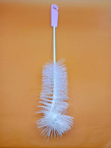 Plastic bottle brush close up.Isolated on an orange background