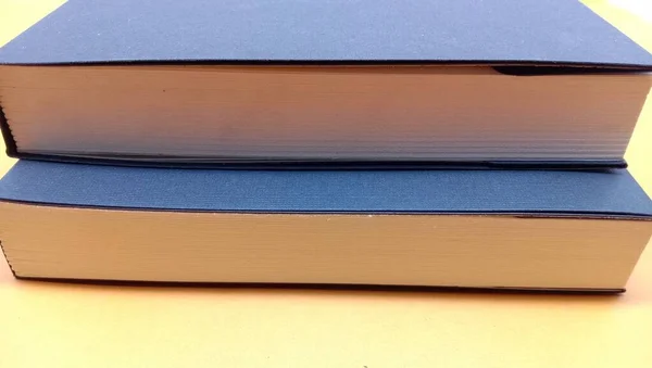 Stack of two books isolated on an orange background.