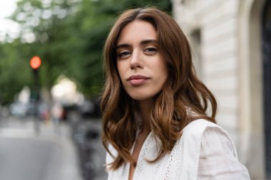 Şık bir kadın Paris 'teki şehir sokağında kameraya bakıyor. 