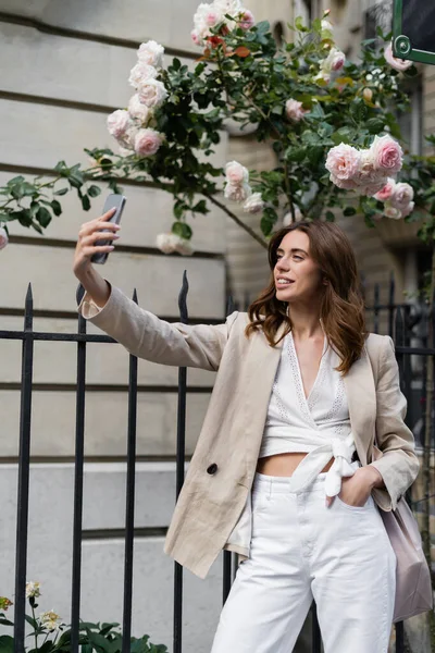 Mujer Elegante Tomando Selfie Teléfono Inteligente Cerca Rosas Florecientes Calle — Foto de Stock