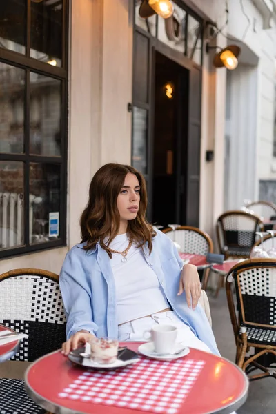 Stijlvolle Vrouw Zit Buurt Van Wazig Koffie Dessert Tafel Outdoor — Stockfoto