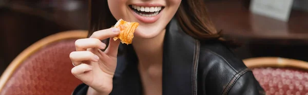 Partial view of happy woman holding fresh croissant in outdoor cafe in paris, banner — Stock Photo
