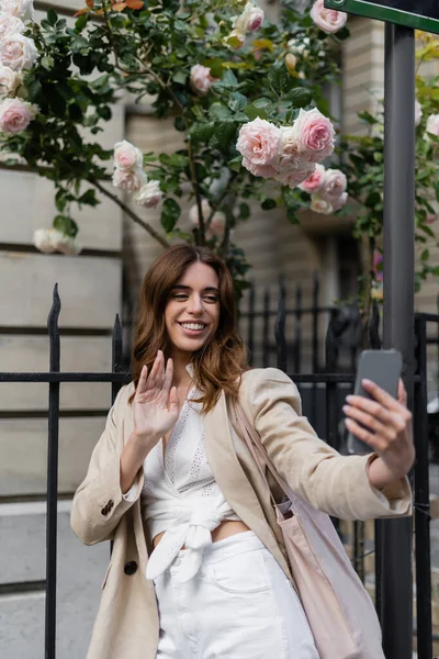 Sorrindo mulher ter chamada de vídeo no smartphone na rua urbana em Paris — Fotografia de Stock