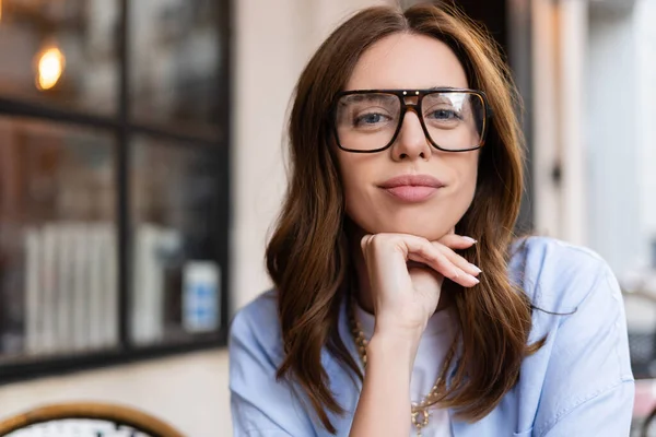 Brunette woman in eyeglasses looking at camera outdoors in France — Stock Photo