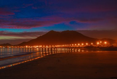 Twilight view of Khorfakkan beach with warm light and its reflection