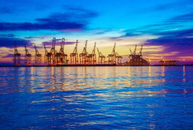  Gün batımında arka planda vinçler